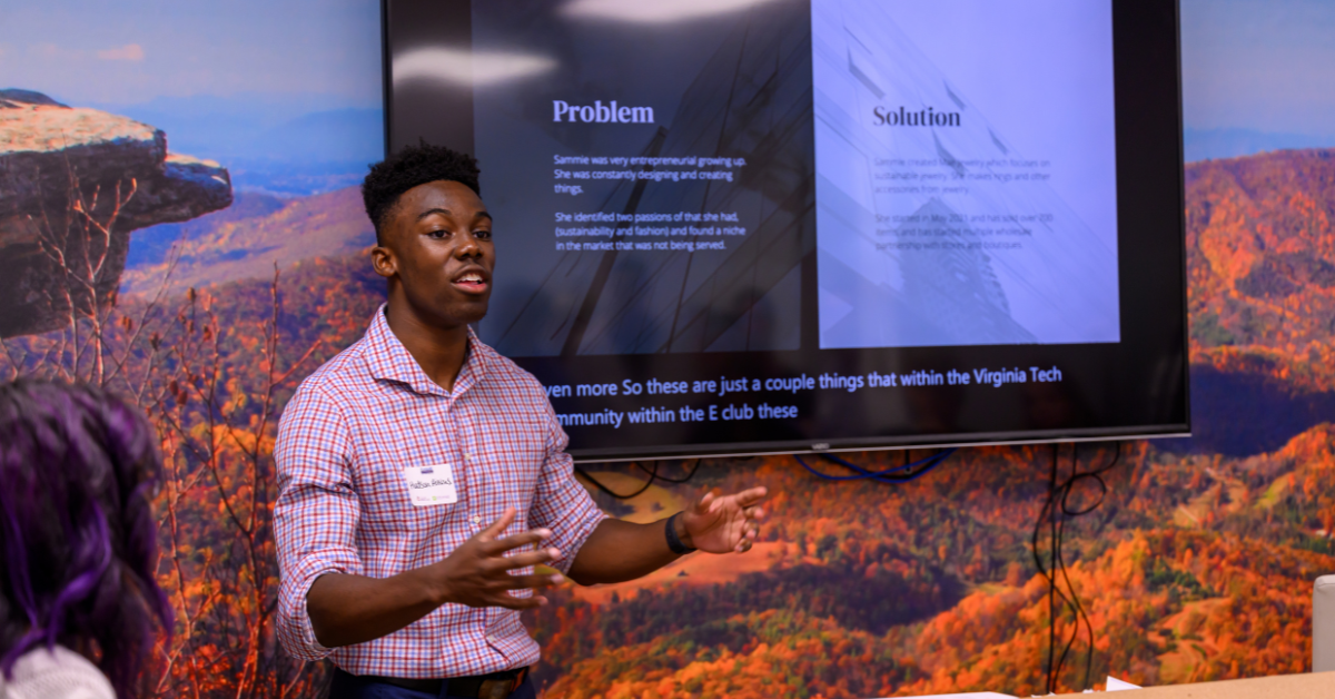 A young professional giving a presentation with a screen behind him